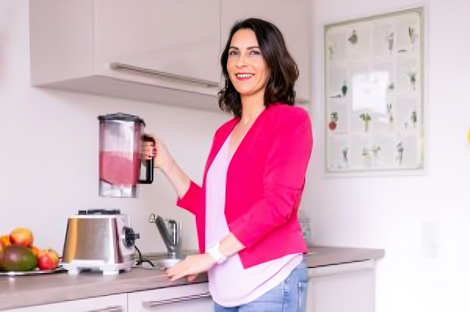 Kathrin Ipse - Expertin für Stressregulation, Nervensystem-Balance und professionelle Hypnose - Kathrin Ipse steht mit einem Mikrofon in der Hand auf der Bühne.